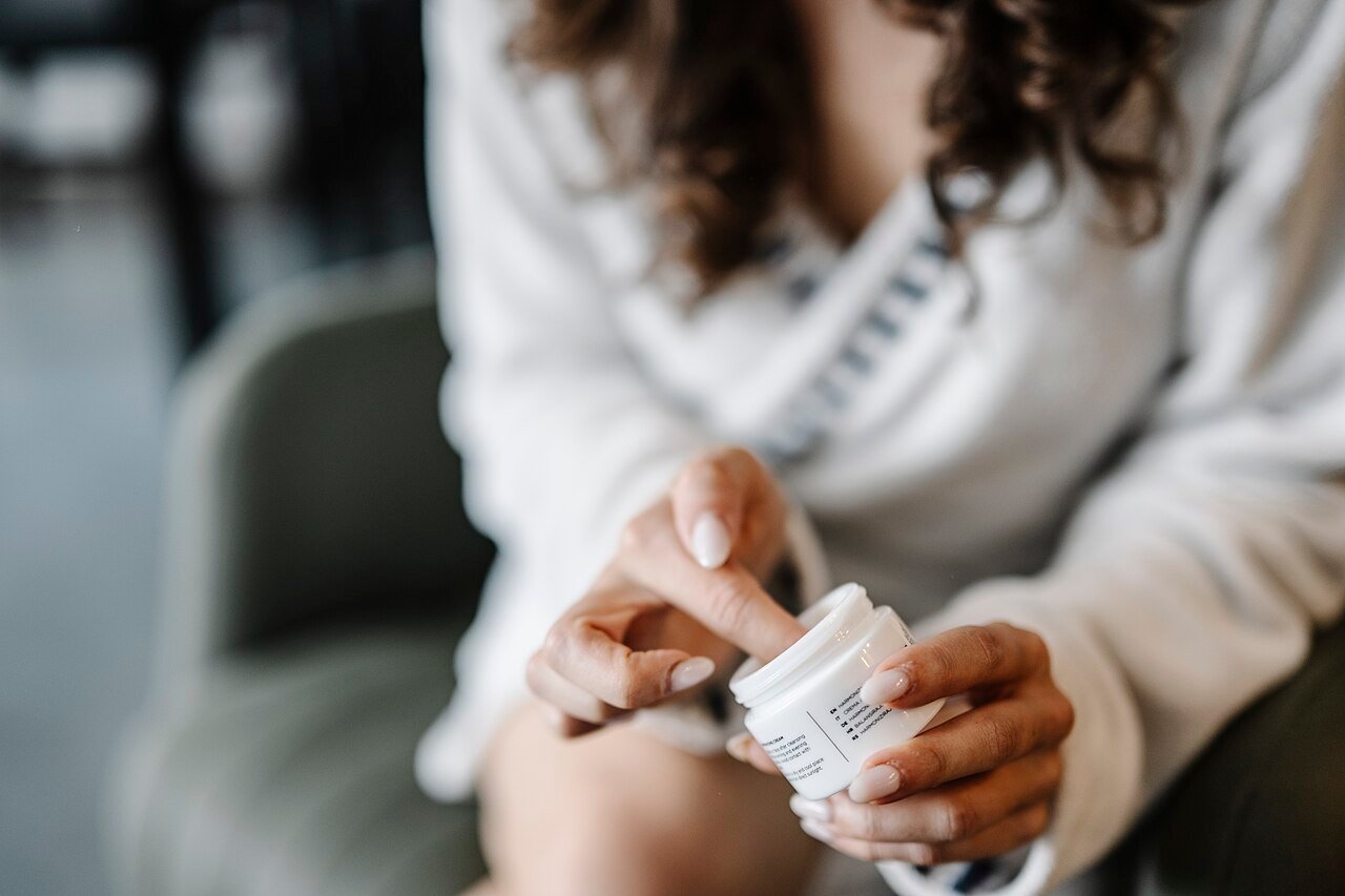 A woman applying hand cream indoors